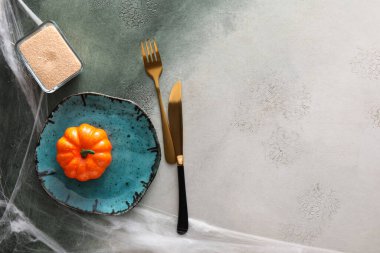 Cadılar Bayramı masa ayarı ve homurdanma arka planında balkabağı