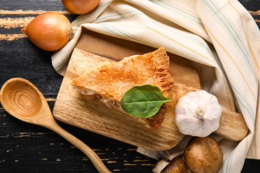 Lezzetli tavuklu turta ve siyah ahşap arka planda sebzeli tahta.