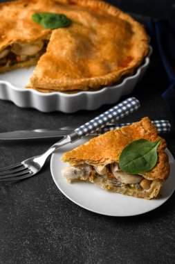 Siyah arka planda lezzetli bir tavuklu turta ile fırın tabağı.