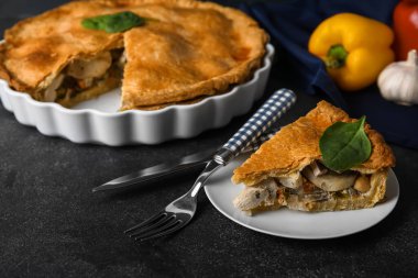 Siyah arka planda lezzetli bir tavuklu turta ile fırın tabağı.