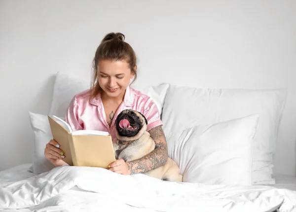 Junge Frau Mit Süßem Mops Liest Buch Schlafzimmer — Stockfoto
