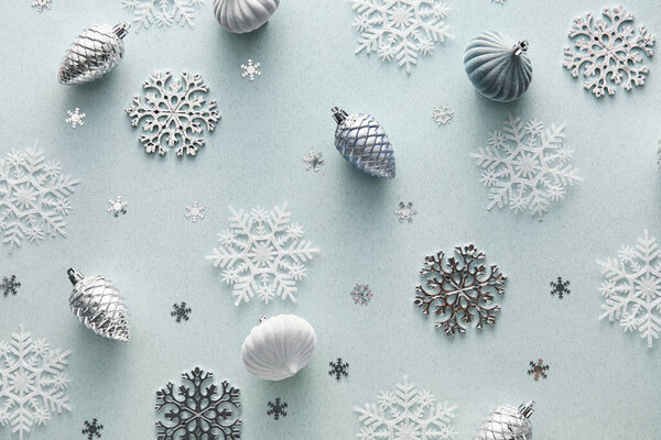 Рождественская композиция с декоративными еловыми конусами и снежинками на светлом фоне