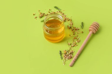 Kavanoz dolusu tatlı bal ve kurutulmuş papatya çiçekleri.