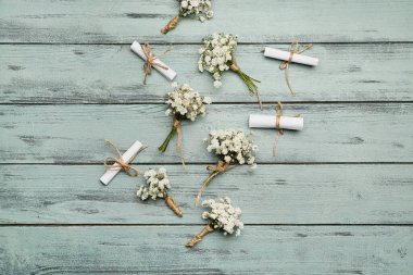 Güzel çingene çiçekleri ve renkli ahşap arka planda düğün davetiyeleri.