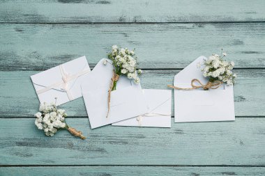 Güzel çingene çiçekleri ve renkli ahşap arka planda düğün davetiyeleri.