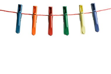 Beyaz arkaplanda ipte asılı renkli mandallar