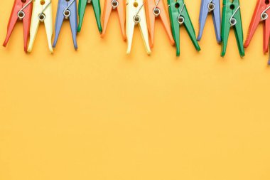 Renk arkaplanındaki birçok plastik mandal, yakın plan