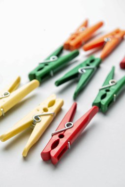 Gri arkaplanda farklı plastik mandallar, yakın plan.