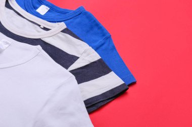 Kırmızı arkaplanda farklı tişörtler, yakın plan