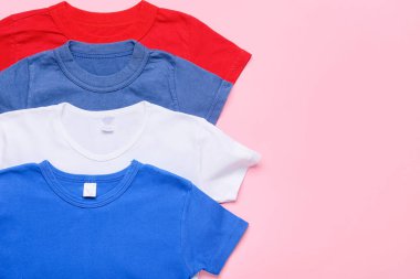 Pembe arka planda birçok şık tişört, yakın plan