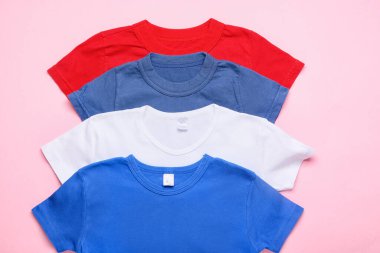 Pembe arka planda birçok şık tişört, yakın plan