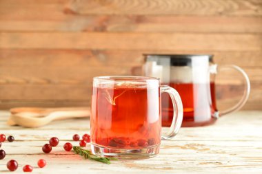 Ahşap masada bir bardak lezzetli kızılcık çayı.