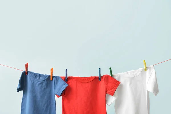 Camisetas Colgando Una Cuerda Sobre Fondo Azul —  Fotos de Stock