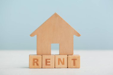 Masada mavi arka planda Kelime RENT ile ahşap ev