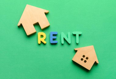 Ahşap evler ve yeşil arka planda kelime RENT