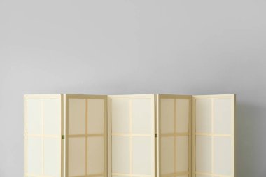 Işık duvarının yanında bej katlanır ekran