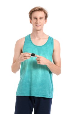 Beyaz arka planda nabız oksimetresi olan sportif bir genç.