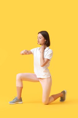 Sportif bayan koşucu renk arkaplanındaki nabzı kontrol ediyor