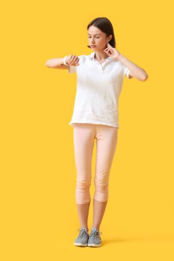 Sportif bayan koşucu renk arkaplanındaki nabzı kontrol ediyor