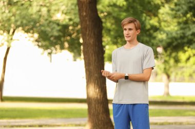 Sportif erkek koşucu dışarıda nabzı kontrol ediyor.