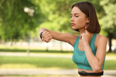 Sportif bayan koşucu nabzını kontrol ediyor.