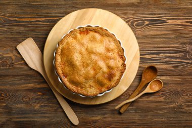 Ahşap arka planda lezzetli tavuklu turta pişirme tabağı