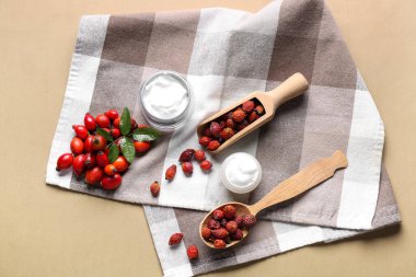 Renkli arka planda kozmetik ürünleri ve gül böğürtlen kavanozları