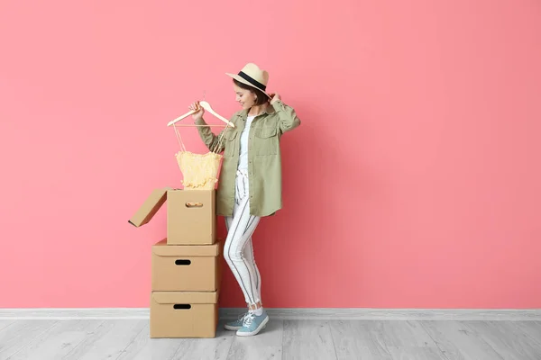 Νεαρή Γυναίκα Κουτιά Ντουλάπα Και Ρούχα Κοντά Στον Τοίχο Χρώμα — Φωτογραφία Αρχείου