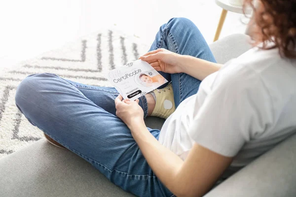 Mujer Joven Con Certificado Regalo Sentado Sofá Casa — Foto de Stock