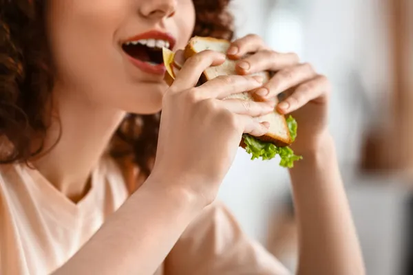 Mooie Jonge Vrouw Eten Smakelijke Sandwich Keuken Closeup — Stockfoto