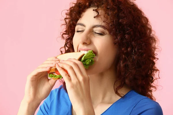 Jonge Vrouw Eten Smakelijke Sandwich Roze Achtergrond — Stockfoto