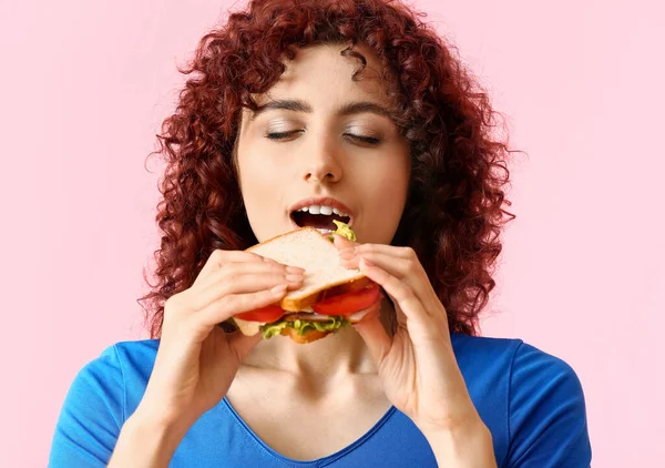 Jonge Vrouw Eten Smakelijke Sandwich Roze Achtergrond — Stockfoto