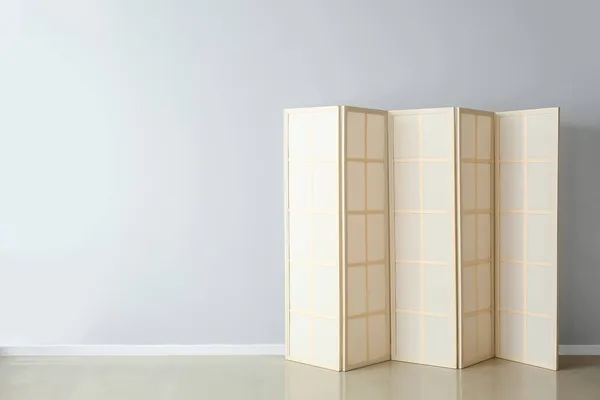 Beige folding screen near light wall