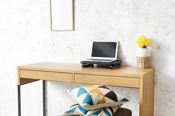 Laptop Bloemen Vaas Houten Bureau Bij Lichte Muur — Stockfoto