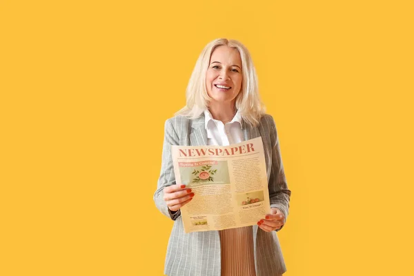 Beautiful Mature Woman Newspaper Yellow Background — Stock Photo, Image