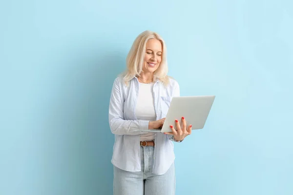 Schöne Reife Frau Mit Laptop Auf Blauem Hintergrund — Stockfoto