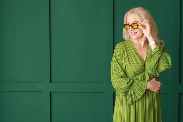 美しいです成熟した女性でサングラス上の緑の背景 — ストック写真