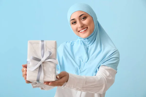 Junge Muslimin Mit Geschenk Auf Farbigem Hintergrund — Stockfoto