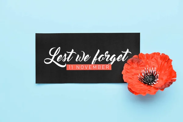 Remembrance Day in Canada. Red poppy flower with card on blue background