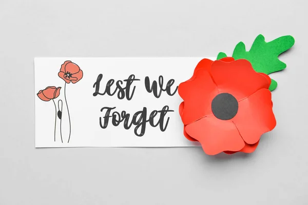 Remembrance Day in Canada. Red poppy flower and card on grey background