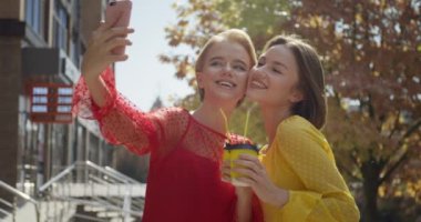 İçkili güzel genç kadınlar dışarıda selfie çekiyorlar.