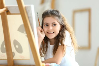 Evde resim yapan sevimli küçük bir kız.