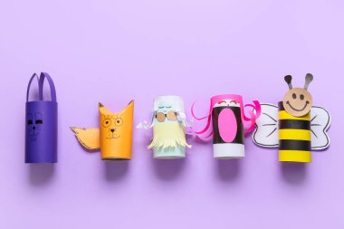 Renk arkaplanındaki boş tuvalet kağıdı tüplerinden yapılmış farklı şekiller