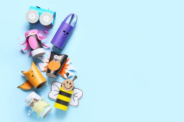 Mavi arka planda tuvalet kağıdı için karton tüplerden yapılmış farklı şekiller