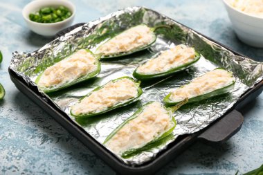 Renkli arka planda pişmemiş jalapeno poppers ile kızartma tavası, yakın plan