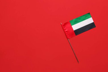 Kırmızı arkaplanda Birleşik Arap Emirlikleri bayrağı