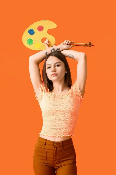 カラーを背景にパレットやブラシを持つ若い女性アーティスト — ストック写真
