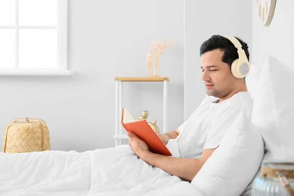 Young Man Reading Book Listening Music Bedroom — Stock Photo, Image