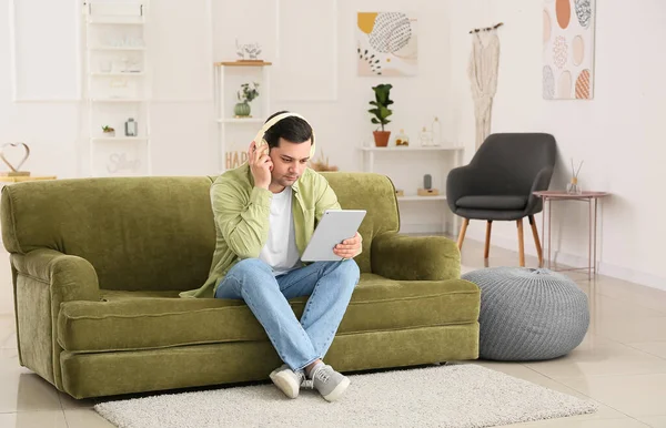 Νεαρός Άνδρας Tablet Υπολογιστή Ακούγοντας Audiobook Στο Σπίτι — Φωτογραφία Αρχείου