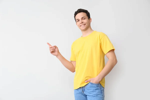 Schöner Junger Mann Stylischem Shirt Zeigt Auf Etwas Auf Hellem — Stockfoto